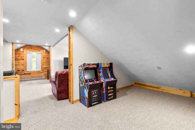 playroom featuring wooden walls, a textured ceiling, a baseboard heating unit, vaulted ceiling, and carpet floors