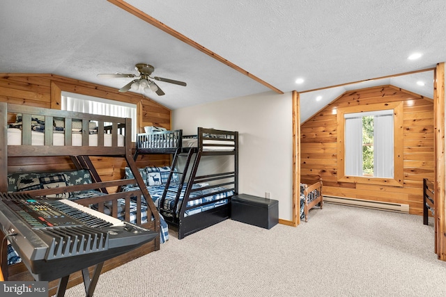 carpeted bedroom featuring a textured ceiling, baseboard heating, wood walls, and vaulted ceiling