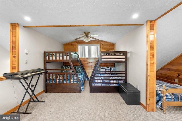 carpeted bedroom with lofted ceiling, ceiling fan, wooden walls, and a textured ceiling