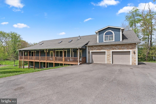 view of front of house with a garage, a front yard, and covered porch