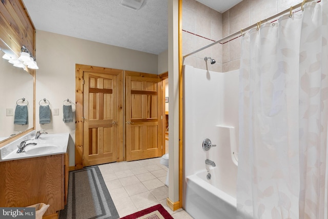 full bathroom featuring toilet, tile patterned floors, vanity, a textured ceiling, and shower / tub combo with curtain