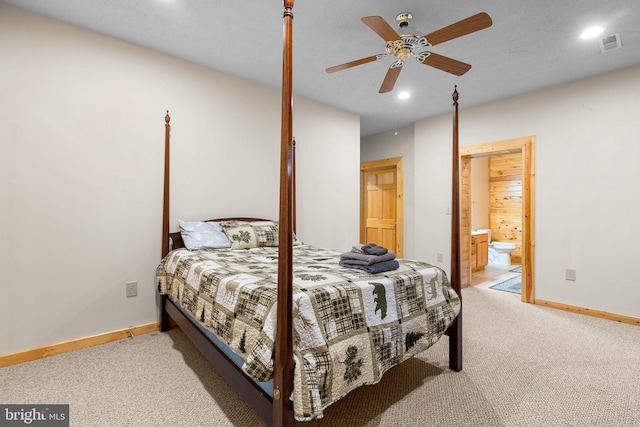 carpeted bedroom with ensuite bath and ceiling fan