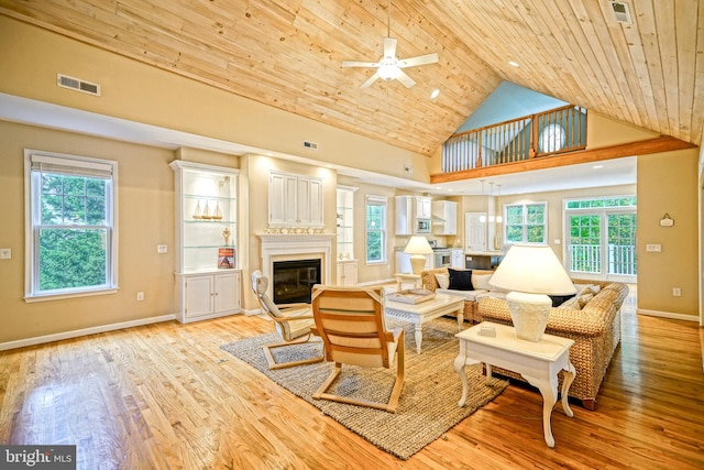 living room with wood ceiling, light hardwood / wood-style flooring, ceiling fan, and plenty of natural light