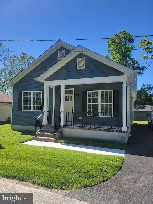 view of front of house with a front yard and covered porch