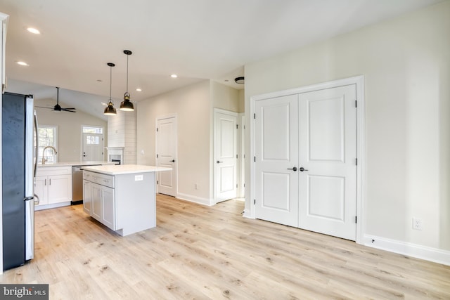 kitchen featuring a center island, vaulted ceiling, stainless steel appliances, sink, and ceiling fan