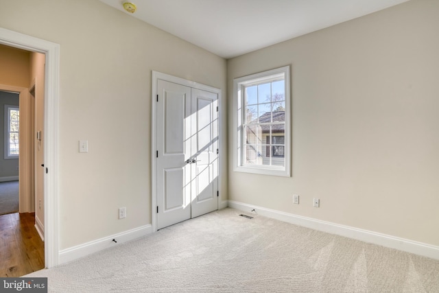 spare room featuring light colored carpet and a healthy amount of sunlight