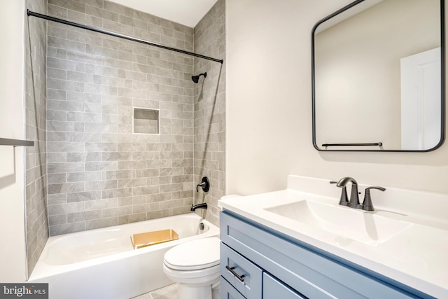 full bathroom featuring tile patterned flooring, tiled shower / bath, toilet, and vanity