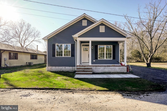 view of front of house with central AC, a front yard, and a porch