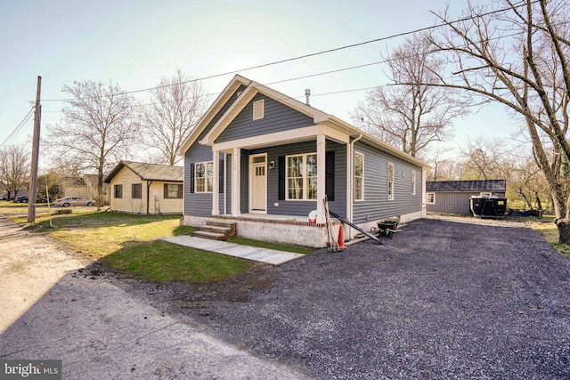 view of front facade with a shed, covered porch, and a front yard