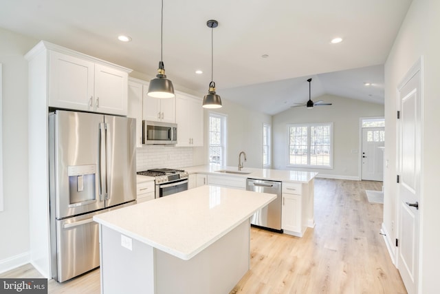 kitchen with white cabinetry, stainless steel appliances, ceiling fan, and kitchen peninsula