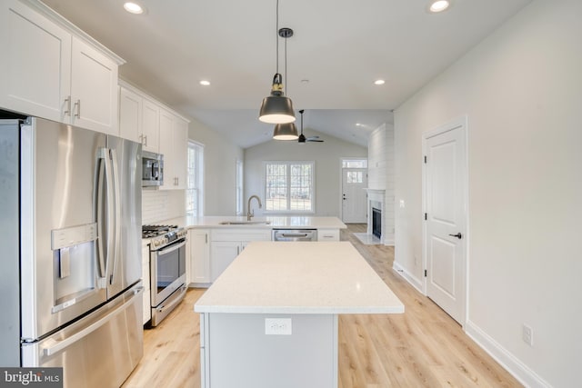 kitchen featuring stainless steel appliances, kitchen peninsula, ceiling fan, and white cabinets