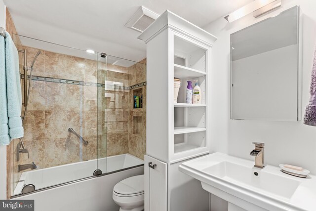 full bathroom featuring enclosed tub / shower combo, toilet, and sink