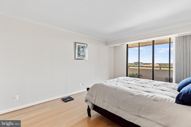 bedroom with ornamental molding and hardwood / wood-style floors