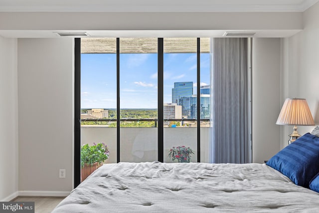 bedroom featuring hardwood / wood-style flooring, ornamental molding, and multiple windows