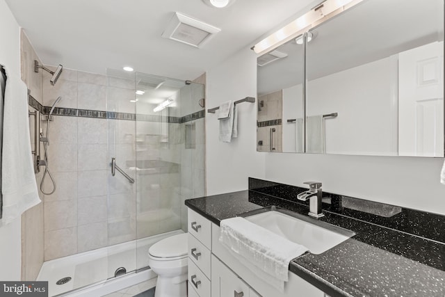 bathroom with vanity, toilet, and an enclosed shower