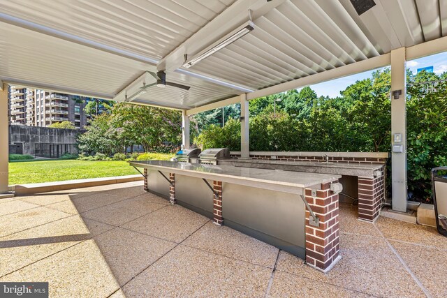 view of patio with area for grilling, a grill, and sink