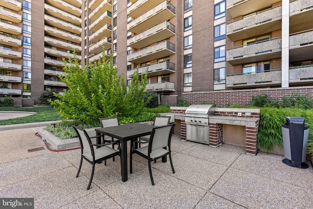 view of patio with a balcony and a grill