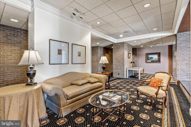 carpeted living room featuring brick wall