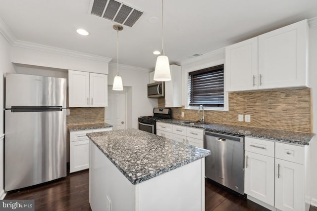 kitchen featuring a kitchen island, dark hardwood / wood-style floors, appliances with stainless steel finishes, sink, and white cabinetry