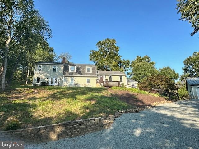 view of front of house featuring a wooden deck and a front lawn