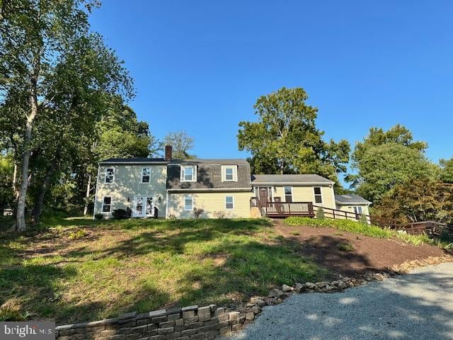 view of front of home featuring a wooden deck and a front lawn