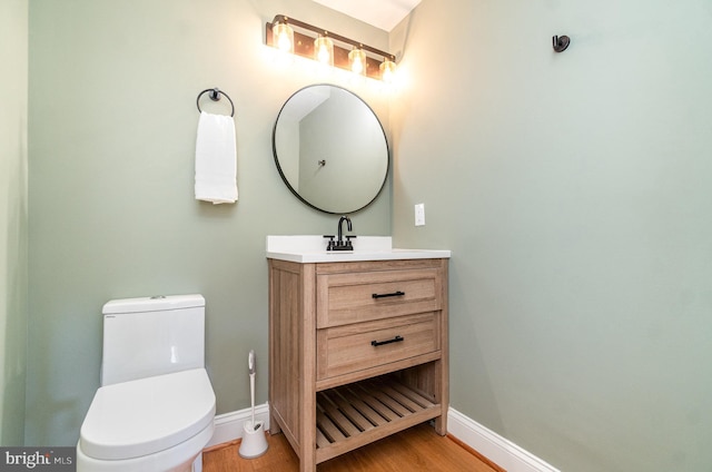 bathroom with vanity, toilet, and hardwood / wood-style floors