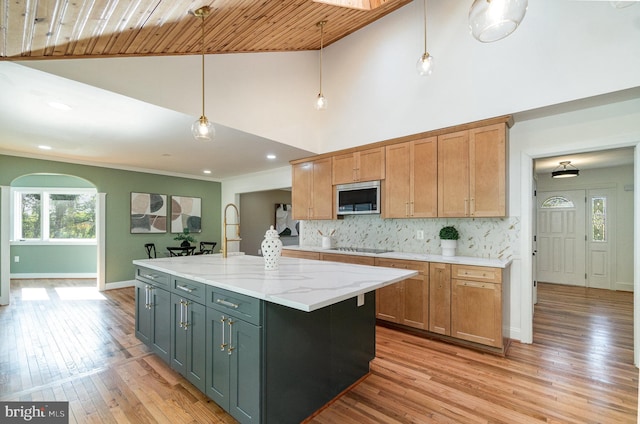 kitchen with wood ceiling, decorative light fixtures, a center island, and light stone counters