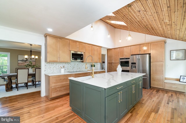 kitchen featuring decorative light fixtures, a kitchen island with sink, stainless steel appliances, and light wood-type flooring