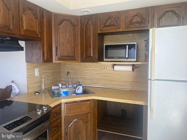 kitchen with backsplash, sink, stainless steel appliances, and extractor fan