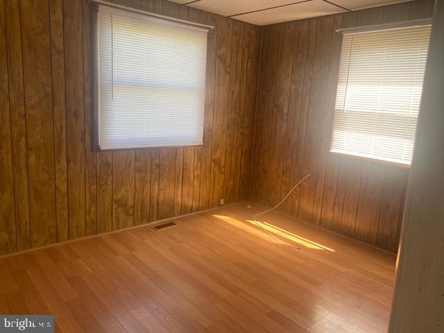 empty room featuring wood-type flooring and wooden walls