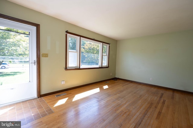 unfurnished room featuring a healthy amount of sunlight and light wood-type flooring