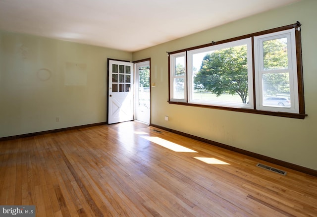 empty room with light hardwood / wood-style flooring