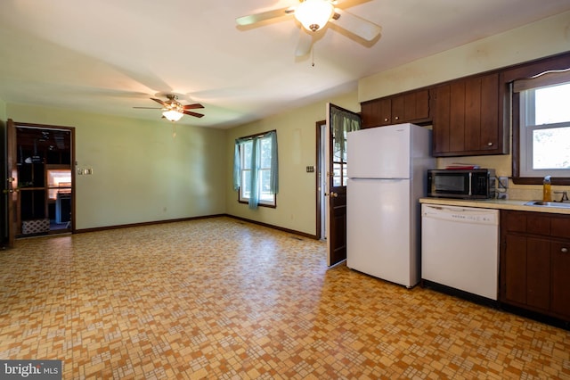 kitchen featuring white appliances, sink, dark brown cabinetry, and ceiling fan