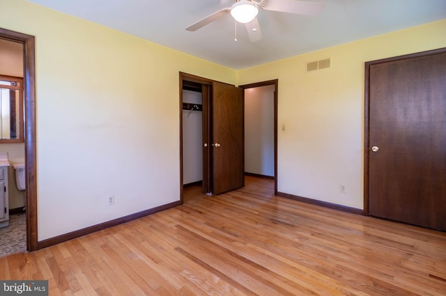 unfurnished bedroom featuring connected bathroom, light wood-type flooring, and ceiling fan