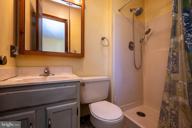 bathroom featuring a shower with shower curtain, toilet, and vanity