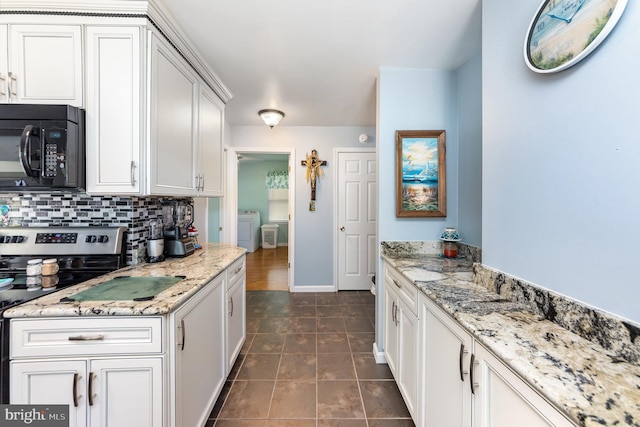 kitchen with tasteful backsplash, white cabinetry, washer / clothes dryer, and black microwave