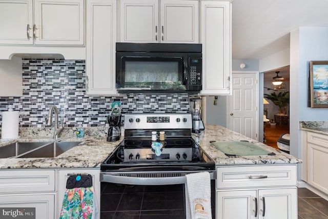 kitchen with tasteful backsplash, black microwave, stainless steel range with electric stovetop, white cabinetry, and a sink