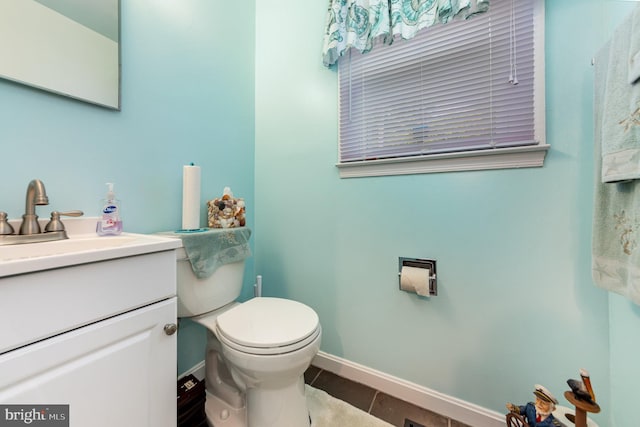 bathroom featuring tile patterned floors, toilet, vanity, and baseboards