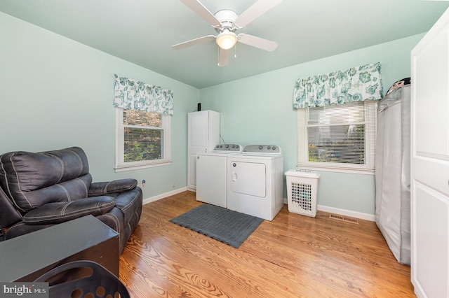 laundry room featuring plenty of natural light, washer and dryer, light wood-type flooring, and baseboards