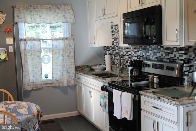 kitchen with light stone counters, white cabinets, backsplash, sink, and stainless steel electric range oven