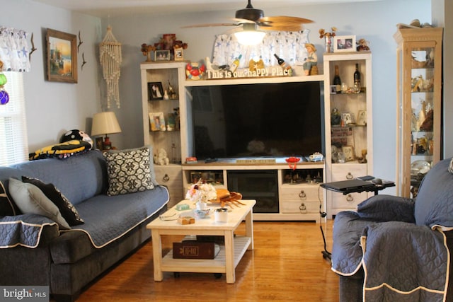 living room featuring hardwood / wood-style floors and ceiling fan