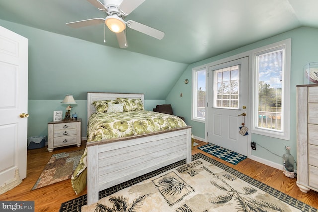 bedroom featuring vaulted ceiling, wood finished floors, baseboards, and ceiling fan