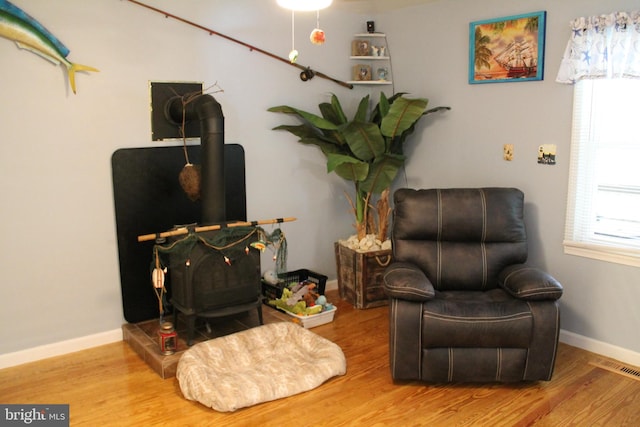 living area featuring a wood stove and hardwood / wood-style floors