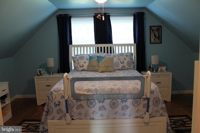 bedroom with vaulted ceiling and dark wood-type flooring