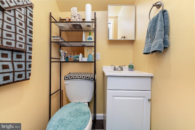 half bathroom featuring vanity and toilet