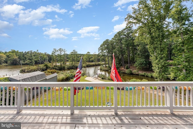 deck with a lawn and a water view