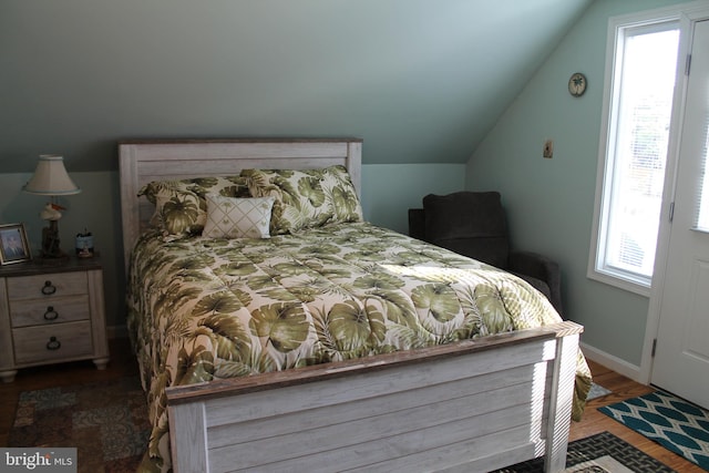 bedroom featuring wood-type flooring and vaulted ceiling