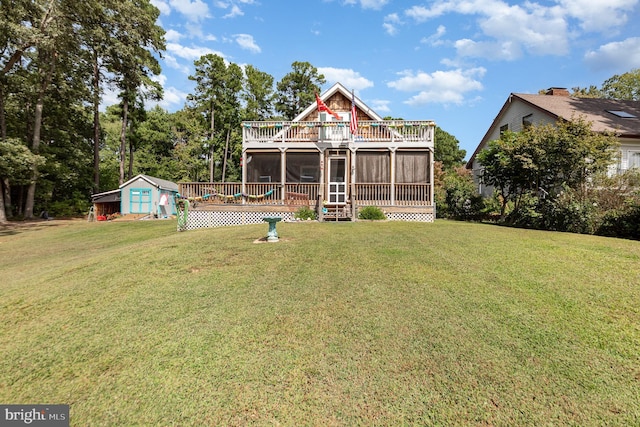 view of front of home featuring an outbuilding, a front lawn, and a sunroom