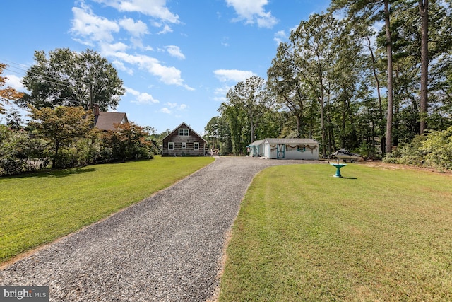 view of front of property with a front lawn, an outdoor structure, and driveway