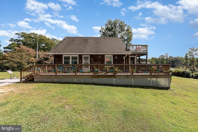 rear view of house with a lawn, roof with shingles, and a wooden deck